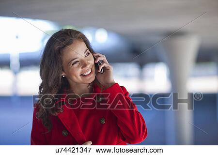 Young woman chatting on smartphone in city underpass View Large Photo Image Stock Photo - Young woman chatting on smartphone in city underpass. Fotosearch