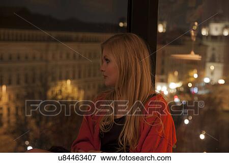 Stock Photo - Young woman enjoying view from hotel room, Vienna, Austria. Fotosearch