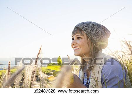 Stock Photo - Young woman enjoying view in fields. Fotosearch