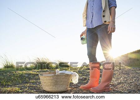 Young woman in wellies standing against sunset View Large Photo Image Stock Image - Young woman in wellies standing against sunset. Fotosearch