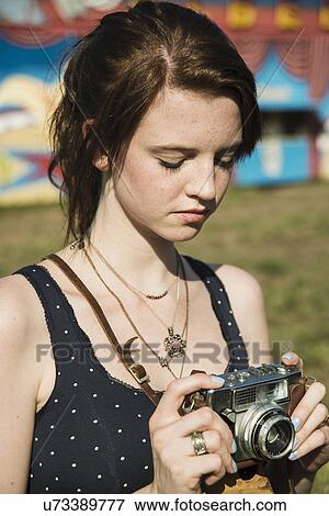 Young woman photographing on SLR camera at funfair View Large Photo Image Stock Photo - Young woman photographing on SLR camera at funfair. Fotosearch