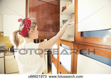 Young woman reaching for cupboard in vintage kitchen View Large Photo Image Stock Image - Young woman reaching for cupboard in vintage kitchen. Fotosearch