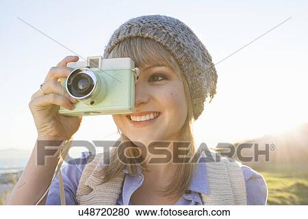 Young woman taking photograph with camera at sunset View Large Photo Image Stock Image - Young woman taking photograph with camera at sunset. Fotosearch