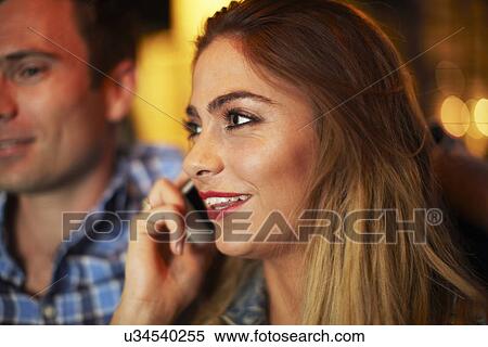 Young woman with boyfriend chatting on smartphone city taxi at night View Large Photo Image Stock Photography - Young woman with boyfriend chatting on smartphone city taxi at night. Fotosearch