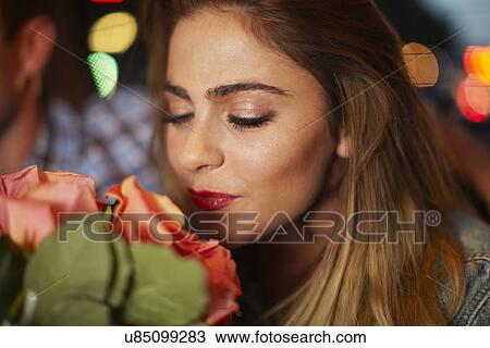 Young woman with boyfriend smelling roses in city taxi at night View Large Photo Image Stock Image - Young woman with boyfriend smelling roses in city taxi at night. Fotosearch