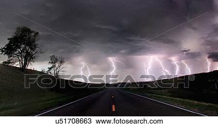 Stock Image - A composite image from 5 images of cloud-to-ground lightening bolts at the end of a rural road, Lexington, Nebraska, USA. Fotosearch