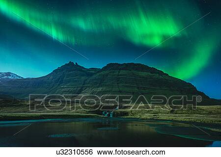 Stock Photograph - Aurora Borealis above Kirkjufellsfoss waterfall, Grundarfjordur, Snaefellsnes, Iceland. Fotosearch