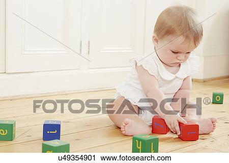 Baby girl playing on floor with building blocks View Large Photo Image Stock Image - Baby girl playing on floor with building blocks. Fotosearch