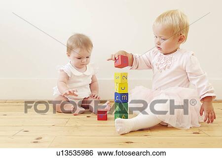 Baby sisters building stack with building blocks View Large Photo Image Stock Photograph - Baby sisters building stack with building blocks. Fotosearch