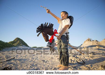 Boy dressed as cowboy with hobby horse in sand dunes View Large Photo Image Stock Photo - Boy dressed as cowboy with hobby horse in sand dunes. Fotosearch
