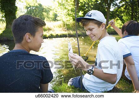 Stock Image - Boy holding fish. Fotosearch