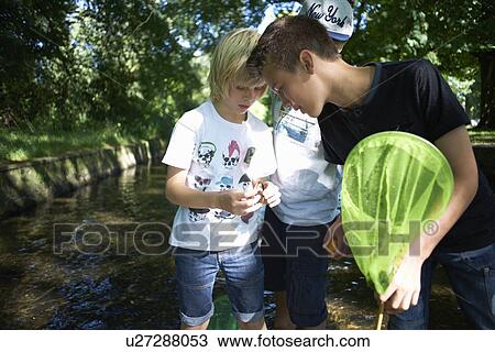 Stock Image - Boy holding fishing net. Fotosearch