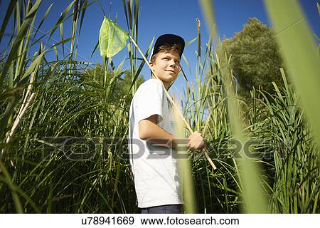 Stock Photo - Boy holding fishing net. Fotosearch