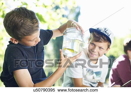 Boy holding jar with fish View Large Photo Image Stock Photography - Boy holding jar with fish. Fotosearch