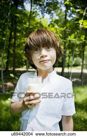 Boy in woods drinking milkshake and pulling a face View Large Photo Image Picture - Boy in woods drinking milkshake and pulling a face. Fotosearch