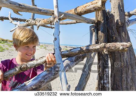Boy making driftwood shelter, Caleri Beach, Veneto, Italy View Large Photo Image Stock Image - Boy making driftwood shelter, Caleri Beach, Veneto, Italy. Fotosearch