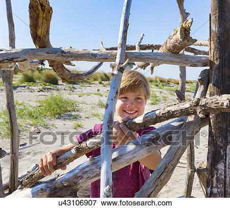 Boy placing driftwood to construct shelter, Caleri Beach, Veneto, Italy View Large Photo Image Stock Photo - Boy placing driftwood to construct shelter, Caleri Beach, Veneto, Italy. Fotosearch