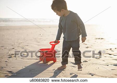 Boy pulling toy truck filled with sand along beach View Large Photo Image Stock Image - Boy pulling toy truck filled with sand along beach. Fotosearch