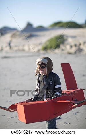 Boy running with toy airplane in sand dunes View Large Photo Image Stock Photo - Boy running with toy airplane in sand dunes. Fotosearch