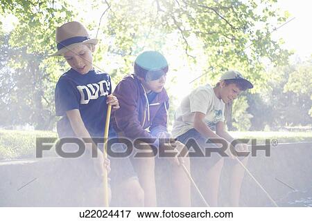 Stock Photo - Boys holding fishing nets in sunlight. Fotosearch