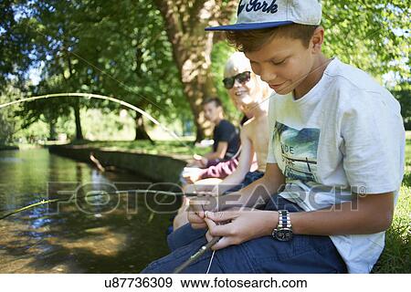 Boys holding sticks, fishing View Large Photo Image Stock Photo - Boys holding sticks, fishing. Fotosearch