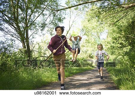 Boys running on track with sticks View Large Photo Image Stock Image - Boys running on track with sticks. Fotosearch