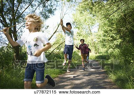 Stock Photography - Boys running on track with sticks. Fotosearch