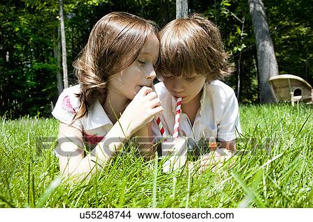 Brother and sister in woods sharing a milkshake View Large Photo Image Picture - Brother and sister in woods sharing a milkshake. Fotosearch