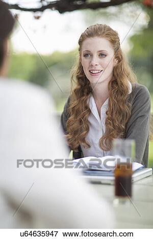 Stock Photo - Businessman and female colleague having informal meeting in garden. Fotosearch