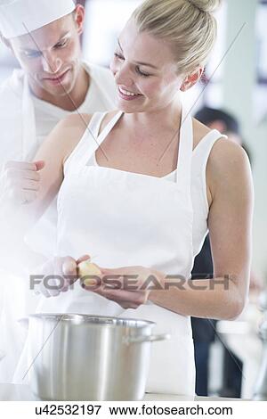 Chef and colleague peeling potatoes in commercial kitchen View Large Photo Image Stock Photo - Chef and colleague peeling potatoes in commercial kitchen. Fotosearch