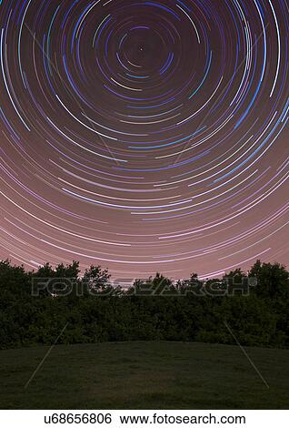 Circles of star trails above rural field at night View Large Photo Image Stock Photograph - Circles of star trails above rural field at night. Fotosearch