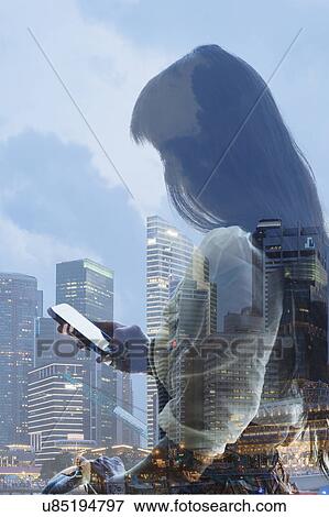 City skyline and young woman using smartphone, reflection on window View Large Photo Image Stock Photo - City skyline and young woman using smartphone, reflection on window. Fotosearch