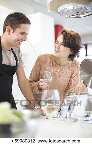 Couple drinking glass of white wine in kitchen View Large Photo Image Stock Image - Couple drinking glass of white wine in kitchen. Fotosearch