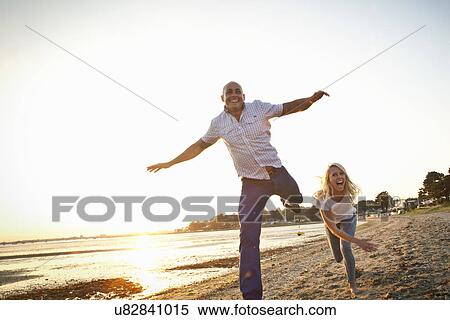 Stock Photography - Couple having fun on beach. Fotosearch