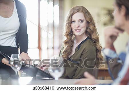 Couple ordering from menu at restaurant table View Large Photo Image Stock Image - Couple ordering from menu at restaurant table. Fotosearch