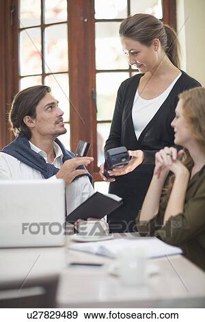 Couple paying bill with credit card in restaurant View Large Photo Image Stock Photo - Couple paying bill with credit card in restaurant. Fotosearch