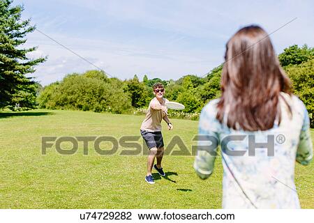 Stock Image - Couple playing disc game in the park. Fotosearch
