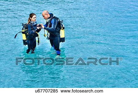 Couple preparing to scuba dive in sea, La Maddalena, Sardinia, Italy View Large Photo Image Stock Photography - Couple preparing to scuba dive in sea, La Maddalena, Sardinia, Italy. Fotosearch