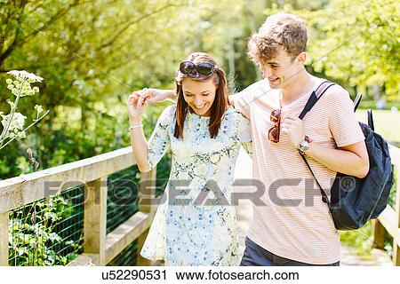 Couple walking over wooden bridge in the park View Large Photo Image Stock Image - Couple walking over wooden bridge in the park. Fotosearch