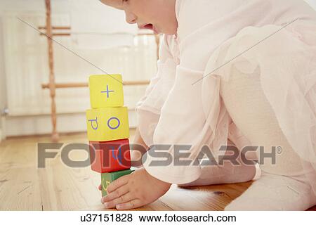 Stock Photo - Cropped shot of baby girl building stack with building blocks. Fotosearch