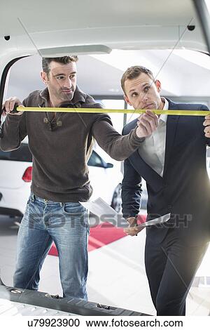 Customer and salesman measuring van interior in car dealership View Large Photo Image Stock Image - Customer and salesman measuring van interior in car dealership. Fotosearch
