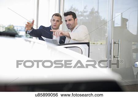 Customer questioning salesman in car dealership View Large Photo Image Stock Photograph - Customer questioning salesman in car dealership. Fotosearch