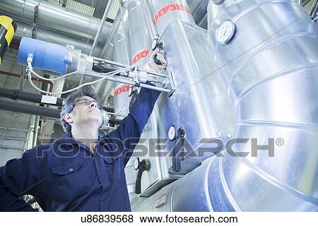 Engineer adjusting valve in power station View Large Photo Image Stock Photo - Engineer adjusting valve in power station. Fotosearch