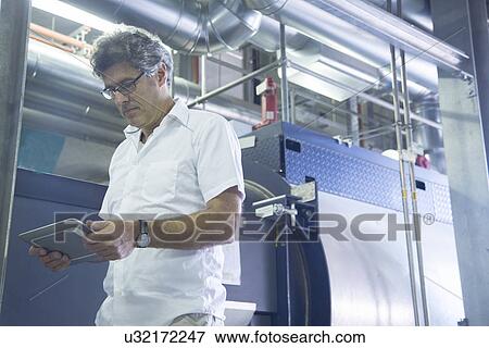 Engineer using digital tablet in power station View Large Photo Image Stock Photo - Engineer using digital tablet in power station. Fotosearch
