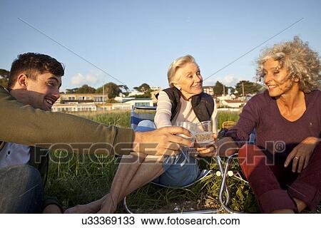 Family members relaxing by beach View Large Photo Image Stock Image - Family members relaxing by beach. Fotosearch