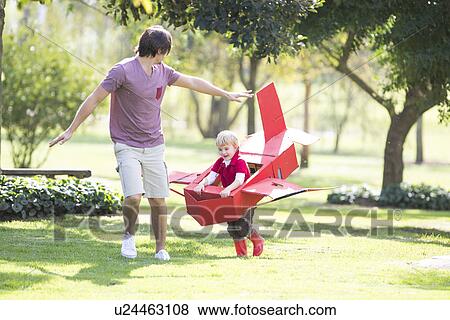 Father and son running with toy airplane in park View Large Photo Image Stock Photo - Father and son running with toy airplane in park. Fotosearch