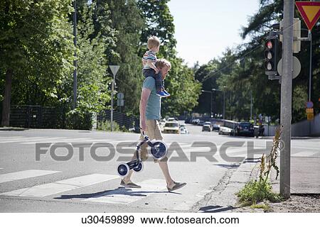 Father shoulder carrying toddler son over pedestrian crossing View Large Photo Image Stock Photo - Father shoulder carrying toddler son over pedestrian crossing. Fotosearch