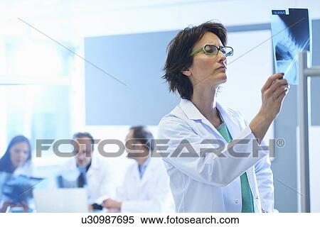 Stock Photography - Female doctor looking at x-ray. Fotosearch