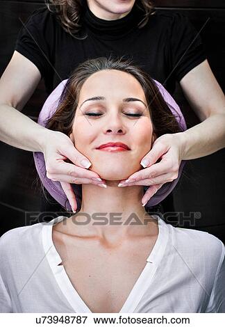 Female masseur massaging young woman's chin in beauty salon View Large Photo Image Stock Photo - Female masseur massaging young woman's chin in beauty salon. Fotosearch
