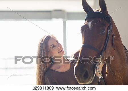 Female stablehand with chestnut horse in stable View Large Photo Image Stock Photo - Female stablehand with chestnut horse in stable. Fotosearch